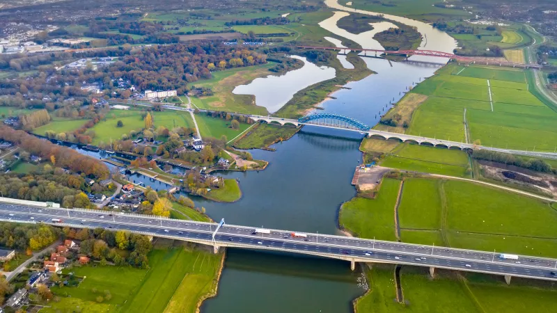 Foto vanuit de lucht van een landschap met bruggen, water en een snelweg. 