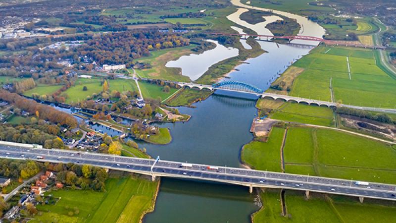 Foto vanuit de lucht van een landschap met bruggen, water en een snelweg.