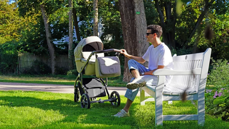 vader in het park met kinderwagen