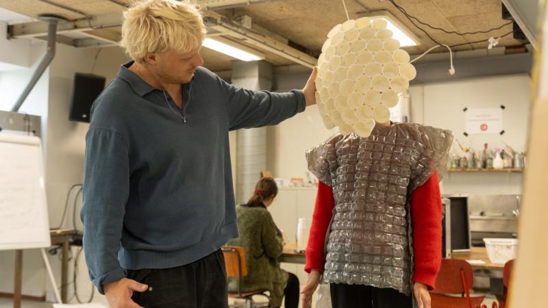 Jongen ontwerpt plastic kostuum