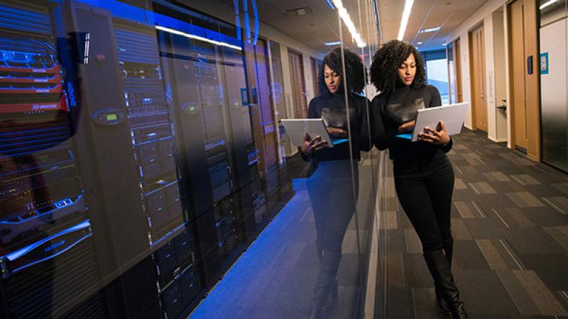 Vrouw met laptop bij server