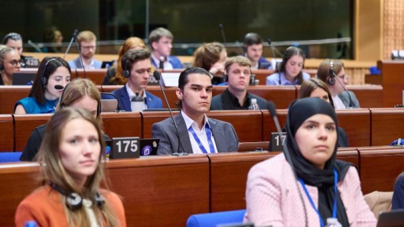 Vergaderzaal van het Congres van Lokale en Regionale Overheden met Enes Hocaoğulları, een Turkse jeugdafgevaardigde, in het midden 
