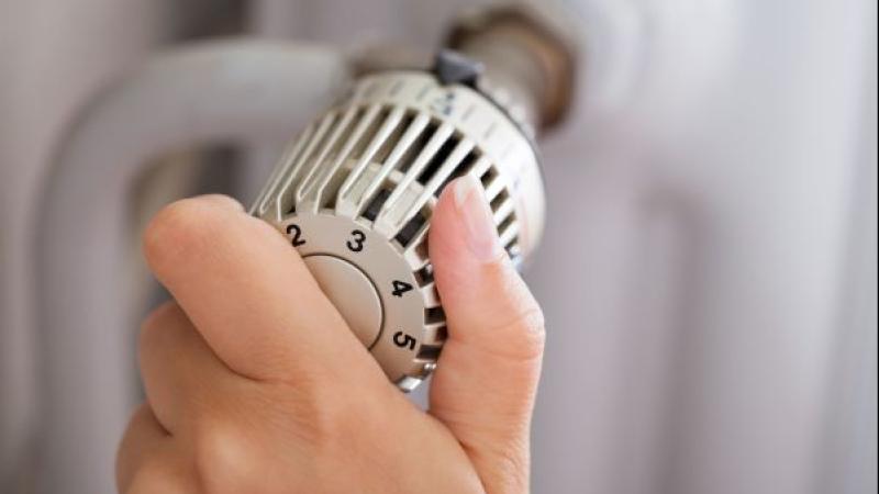 Close-up van hand die aan radiatorknop draait