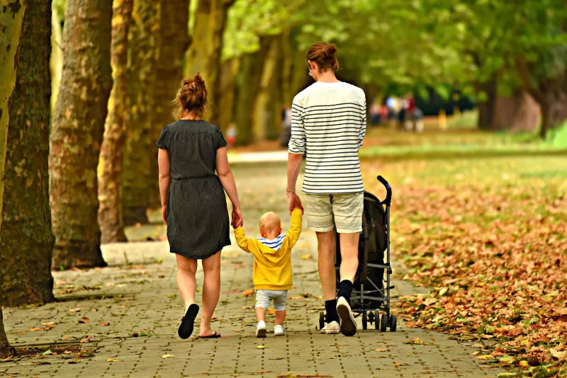 kind aan de hand van ouders in park