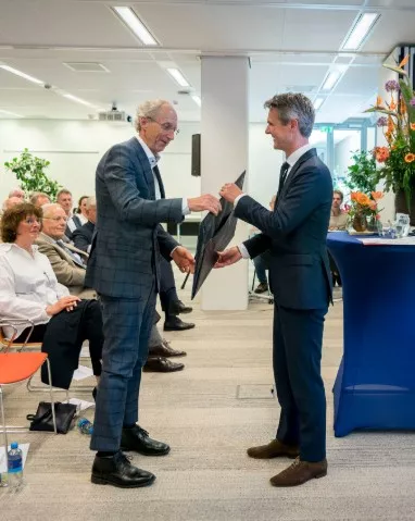 Pieter Jeroense overhandigt een afscheidscadeau aan Peter Knip
