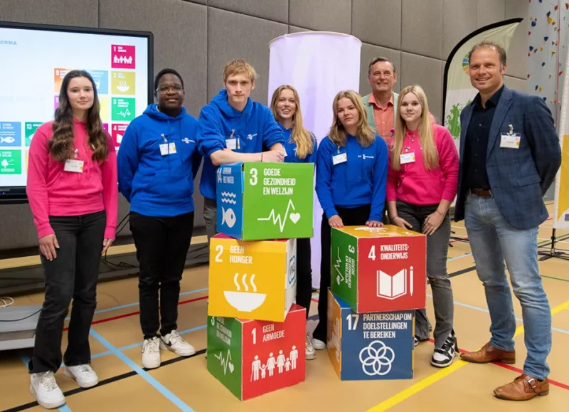 Een aantal kubussen met Global Goals erop, met enkele jongeren en 2 volwassenen