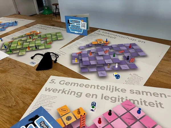 drie van de spelborden op een tafel met de spelregels