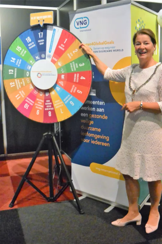 Burgemeester Annemarie Penn-te Strake met een rad van fortuin met alle Global Goals erop